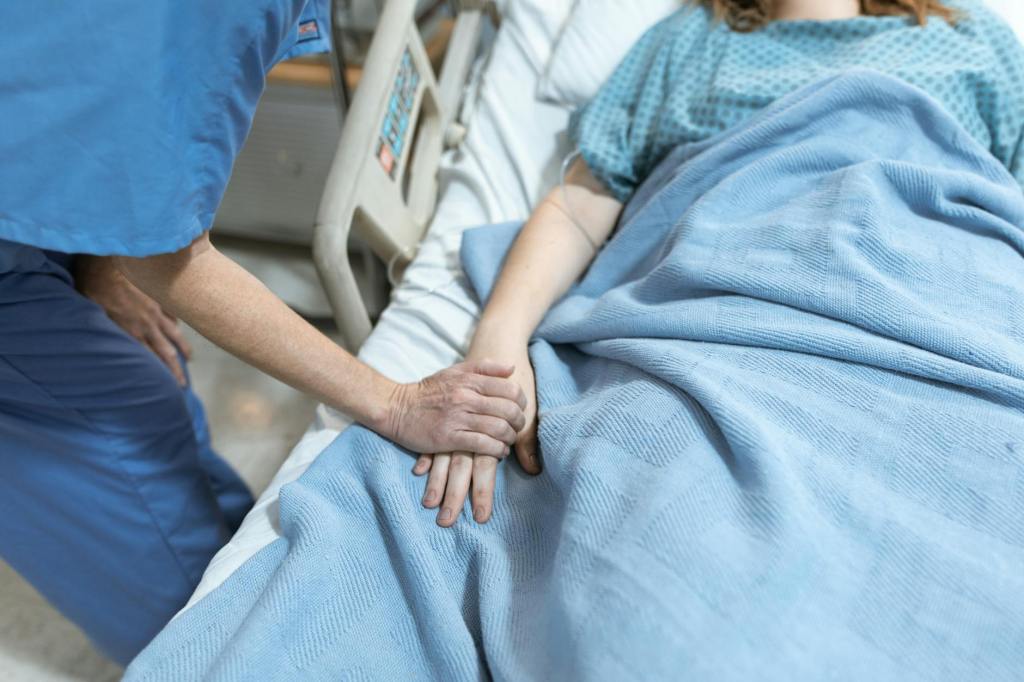 person in blue scrub suit holding the hand of a patient