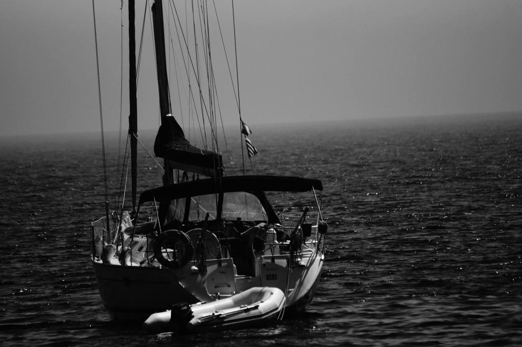 grayscale photography boat on body of water